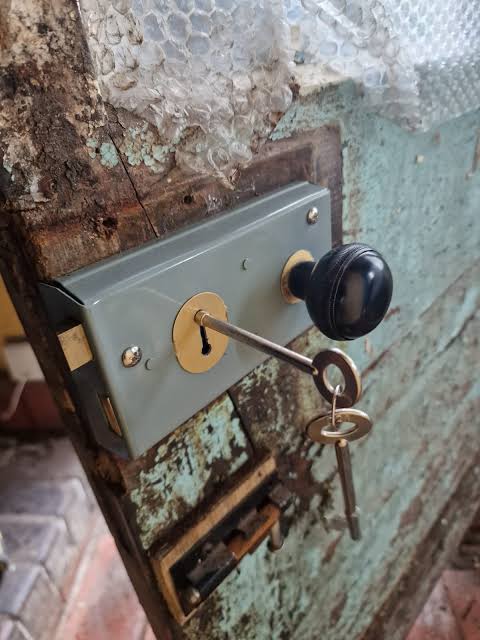 Cerrajero profesional manipulando cilindro de seguridad en puerta blindada